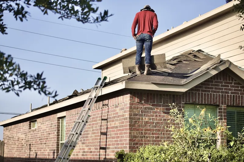 Professional roofer working on a residential roof in Littleton